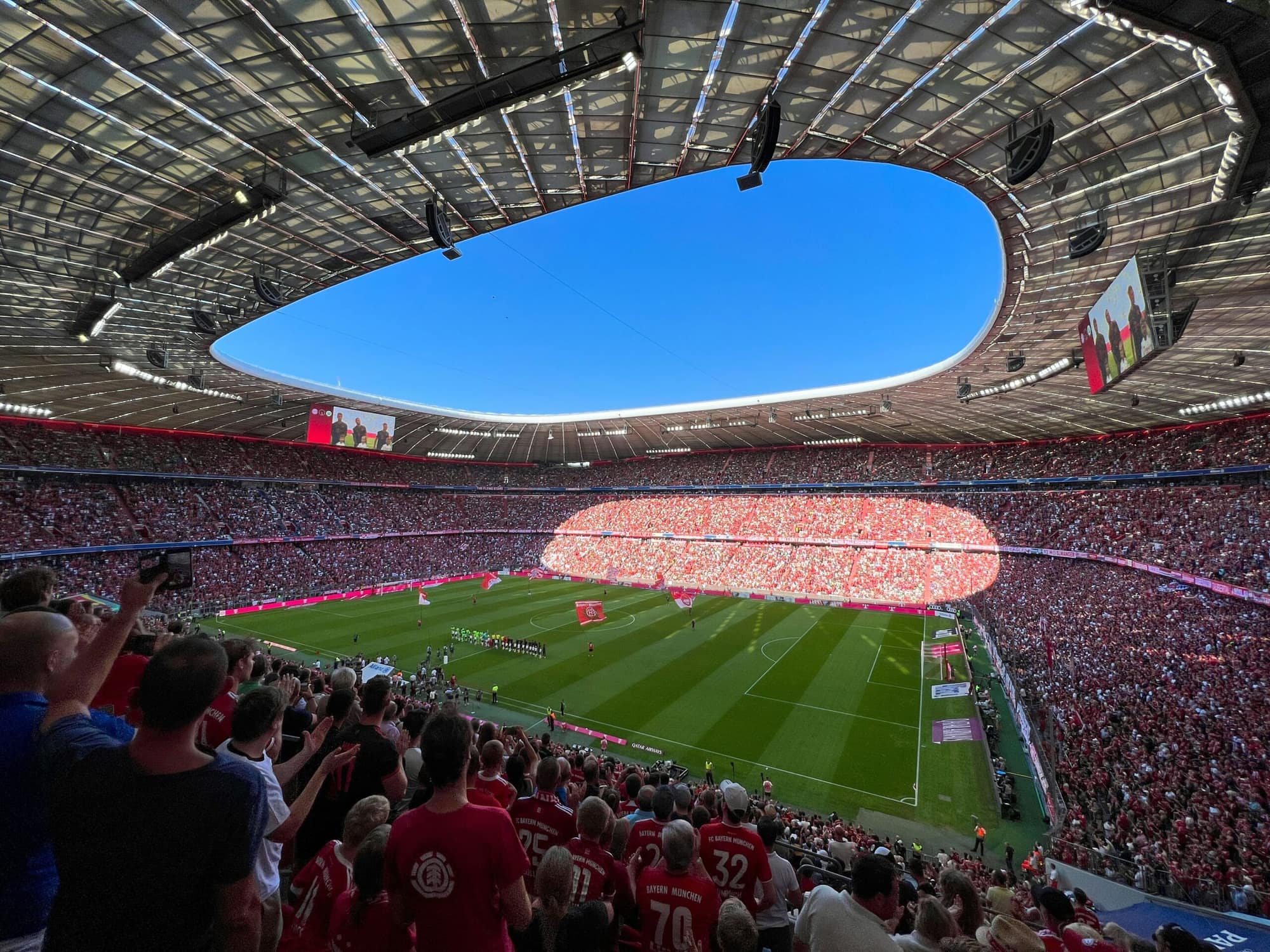 Sold-out Allianz Arena in Munich as the teams walk out, seen from the stands with the pitch and roof