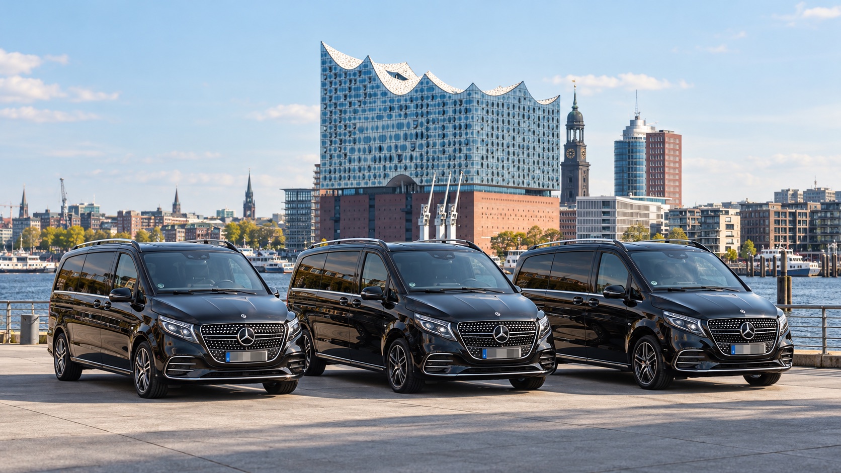 Drei schwarze Mercedes-Benz V-Klassen nebeneinander an der Elbe in Hamburg, dahinter die Elbphilharmonie und die Skyline der HafenCity