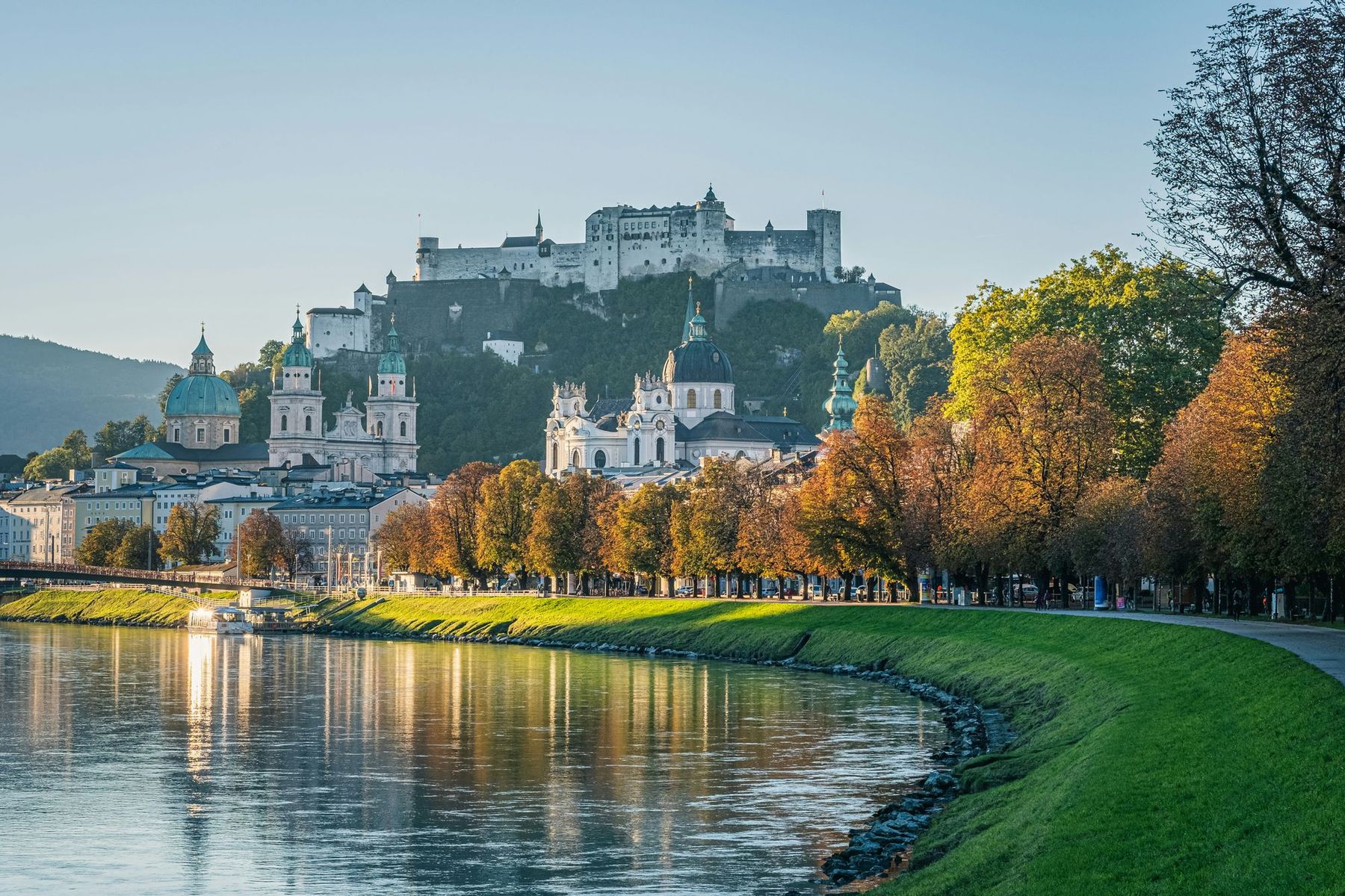 Salzburger Altstadt mit Dom, Kollegienkirche und der Festung Hohensalzburg, im Vordergrund die Salzach im Herbstlicht