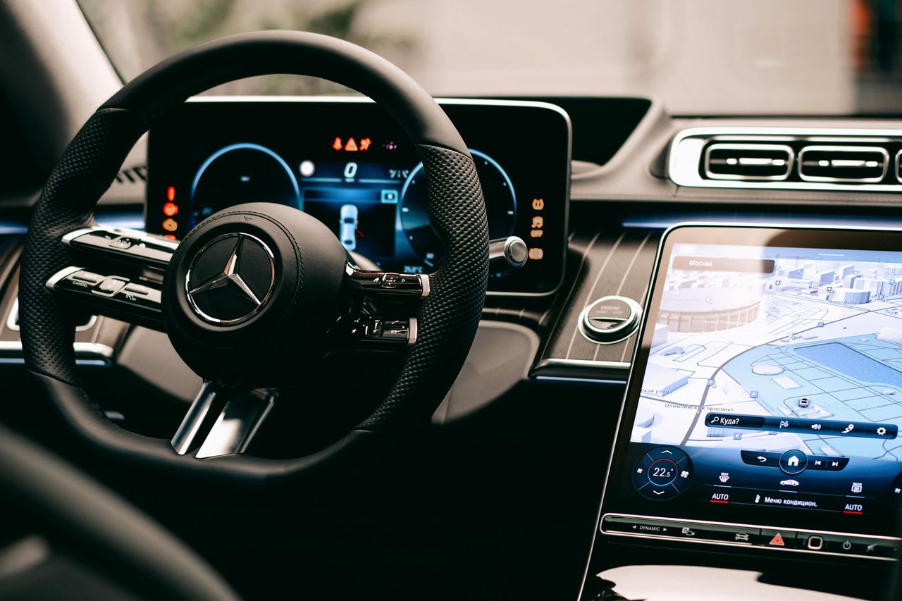 Cockpit of a Mercedes-Benz saloon with steering wheel, digital instrument cluster and large central display