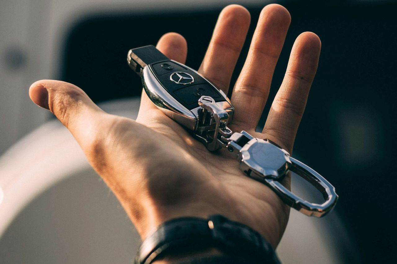 Open hand holding a Mercedes-Benz car key