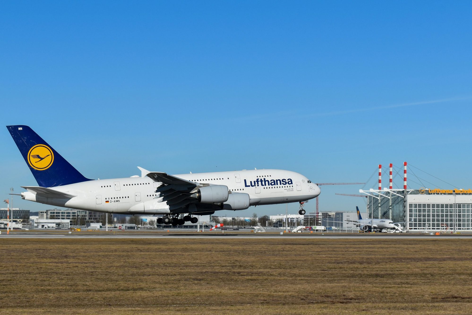 Lufthansa Airbus A380 landing at Munich Airport, with the Lufthansa Technik hangar in the background