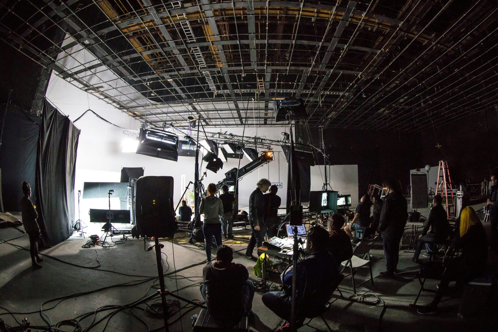 Film set with spotlights, camera crane and crew in a studio