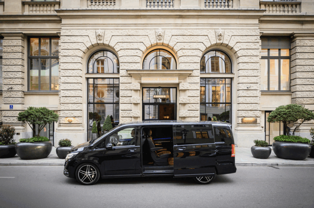 Luxuriöser schwarzer Mercedes-Van von Ayden Chauffeurs & Limousines vor der Bayerischen Staatsbank – stilvoller Chauffeurservice in München.