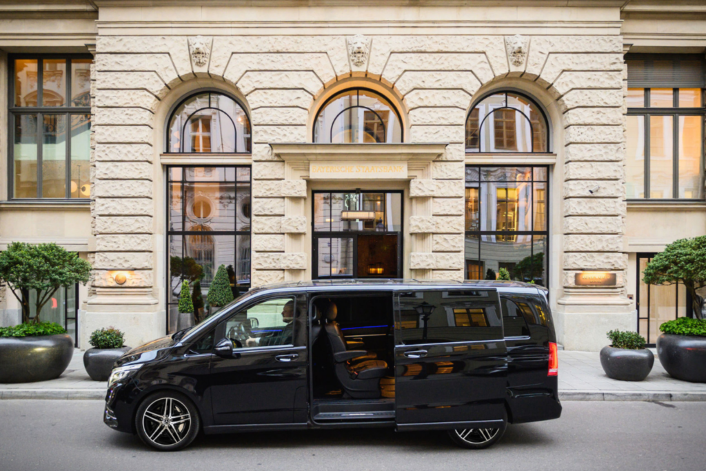 Mercedes V-Klasse für den Chauffeurservice in München von Ayden Chauffeurs & Limousines vor einem Premiumhotel.